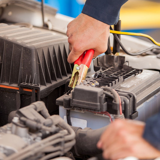 A technician connects jumper cables to a car battery during a roadside assistance jump start in Markham, Ontario.